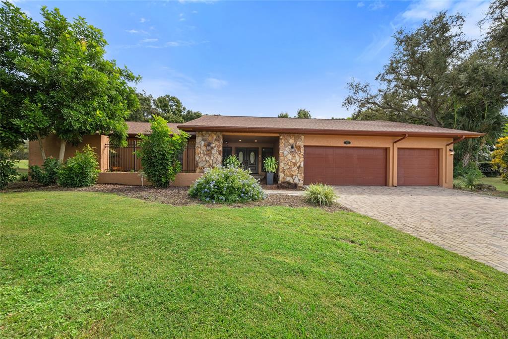 A single-story house with a stone-accented entryway, a two-car garage, and a paved driveway — 2674 CONCORDE COURT, CLEARWATER, FL