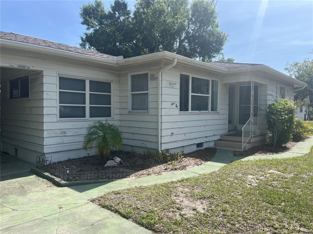 A single-story house with white horizontal siding, a covered entryway, and a concrete walkway — 2415 PELICAN DRIVE, SARASOTA, FL