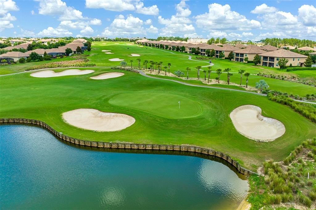 An aerial view shows a golf course green with sand bunkers and a nearby pond — 1484 BUNKER DRIVE, DAVENPORT, FL