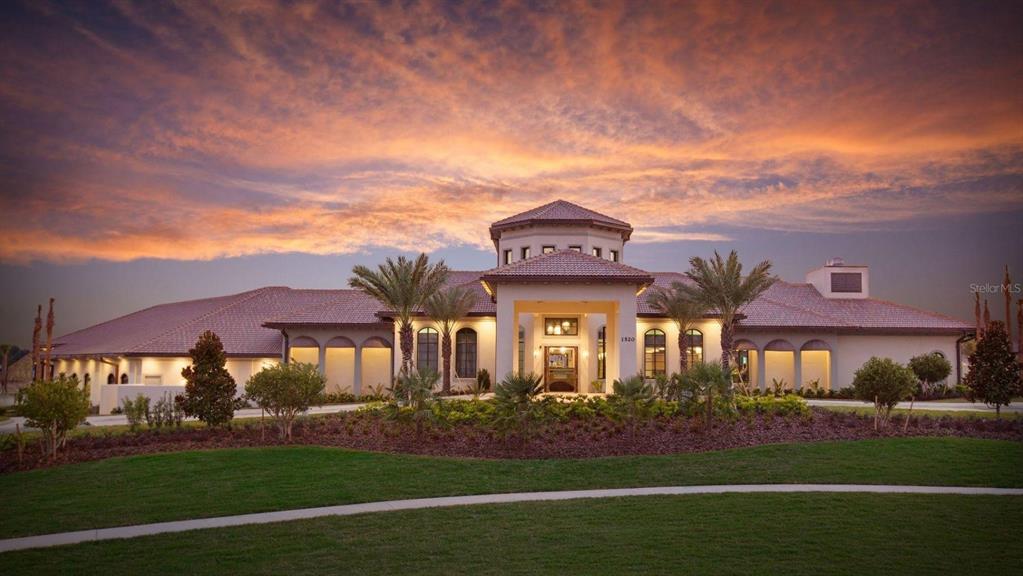 A large, single-story Mediterranean-style house with a tiled roof at sunset — 1484 BUNKER DRIVE, DAVENPORT, FL