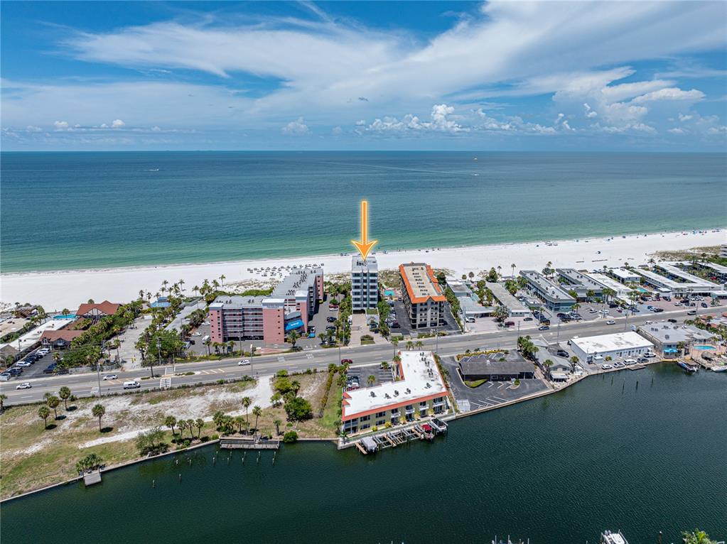 An aerial view shows a beachfront condominium building marked by an arrow — 3910 GULF BOULEVARD UNIT 400, ST PETE BEACH, FL