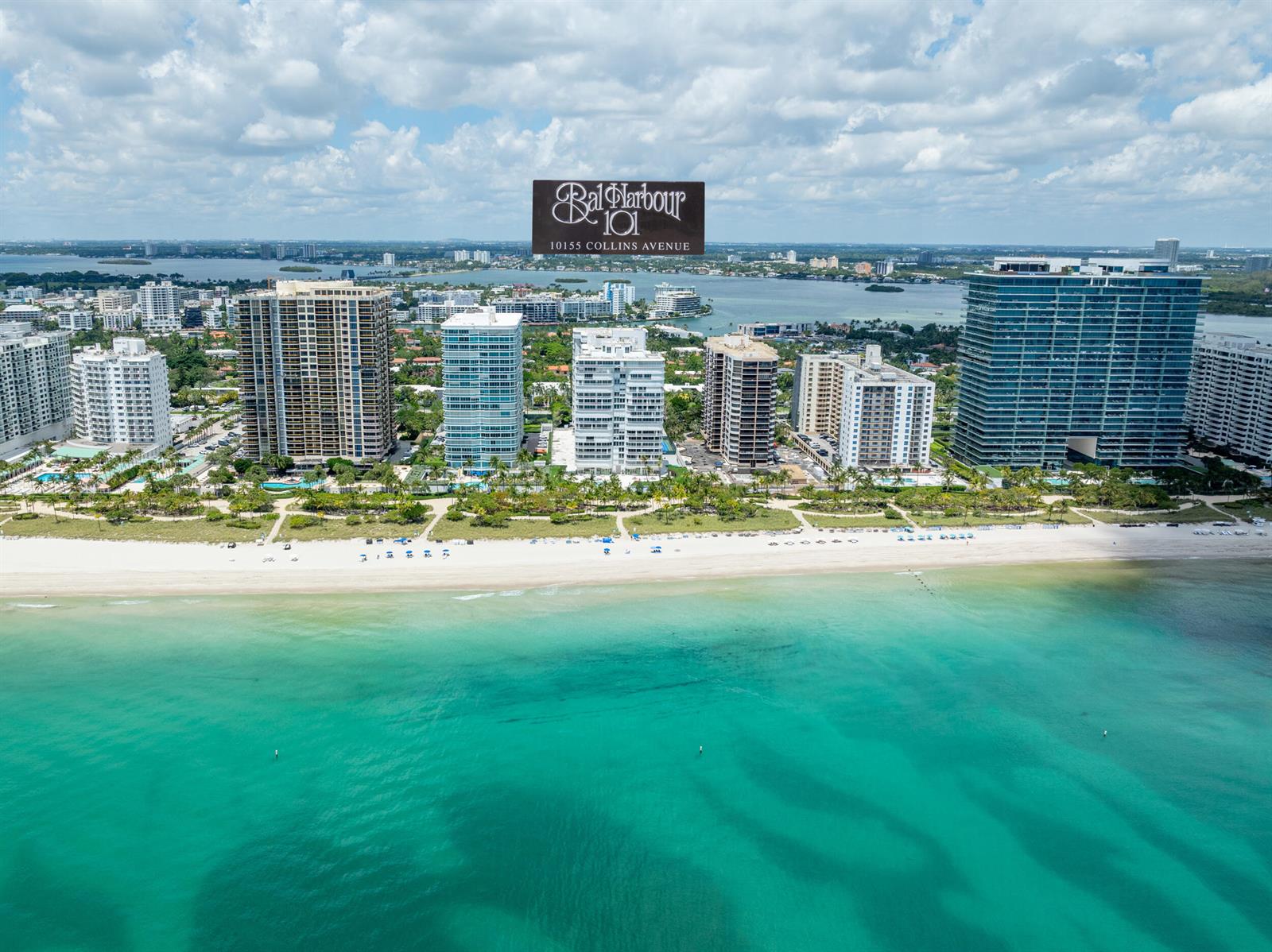 An aerial view of high-rise residential buildings along a sandy beach and turquoise ocean — 10155 Collins Avenue # 1401, Bal Harbour FL 33154, BAL HARBOUR, FL