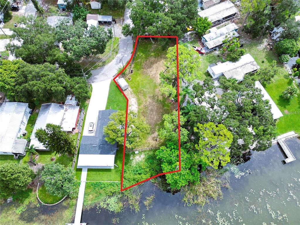 An aerial view shows a vacant, irregularly shaped waterfront lot outlined in red — 31 SUNSET CIRCLE, LAKE ALFRED, FL