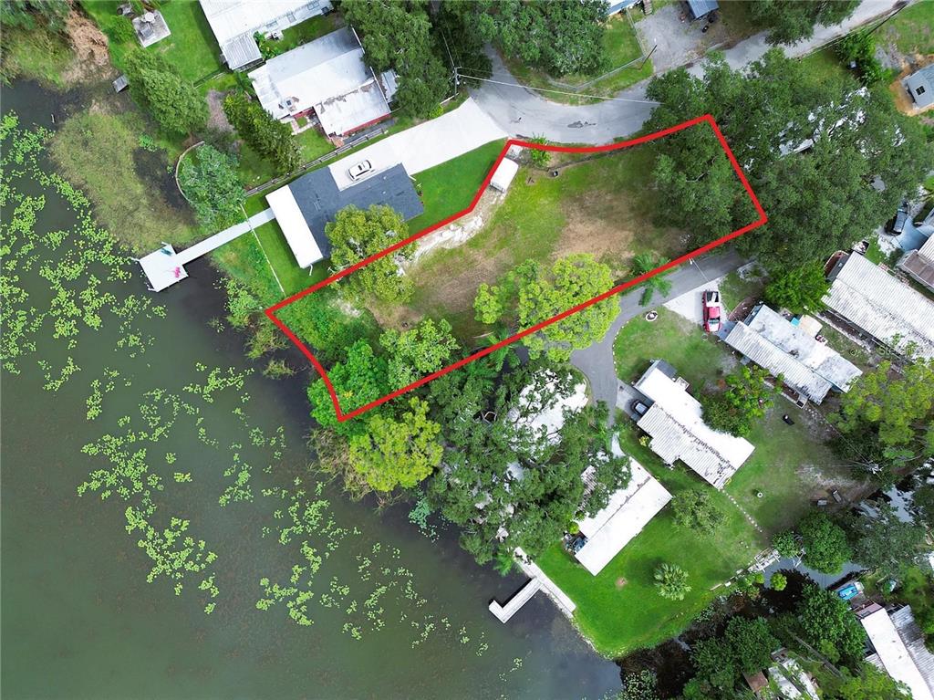 An aerial view shows a waterfront lot outlined in red next to a house — 31 SUNSET CIRCLE, LAKE ALFRED, FL