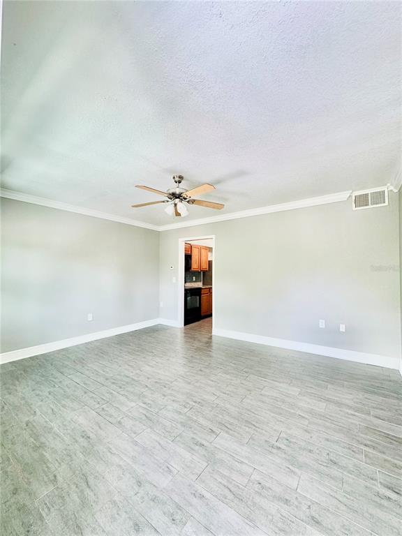 A living room with light gray walls, wood-look tile flooring, and a ceiling fan — 1921 DR MARTIN LUTHER KING JR STREET N UNIT A10, ST PETERSBURG, FL