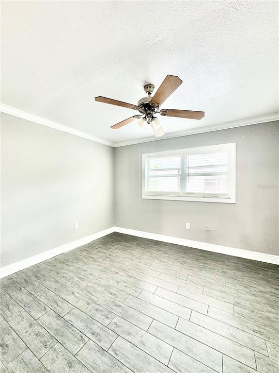 An empty room features gray walls, white trim, a ceiling fan, and wood-look tile flooring — 1921 DR MARTIN LUTHER KING JR STREET N UNIT A10, ST PETERSBURG, FL