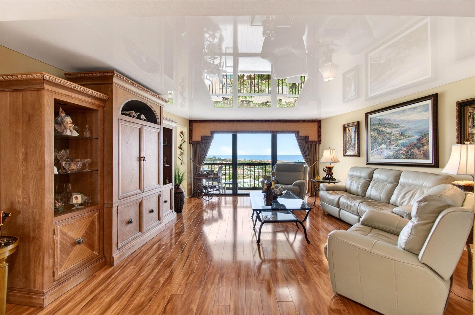 A living room with wood floors, a glossy ceiling, and a view of the ocean — 4740 S Ocean Boulevard # 1503, Boca Raton FL 33487, BOCA RATON, FL