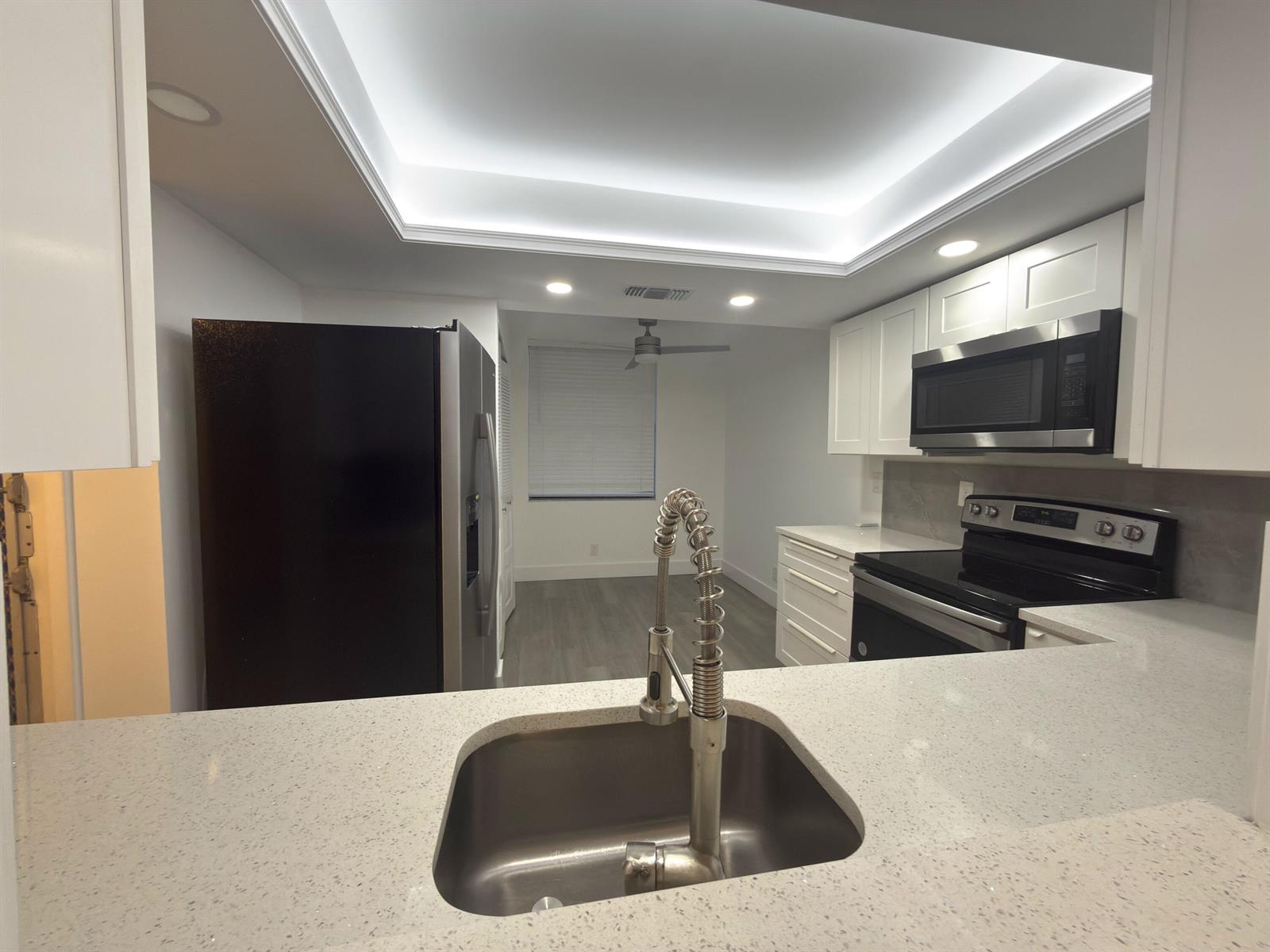 A kitchen with white cabinets, quartz countertops, stainless steel appliances, and a tray ceiling — 7460 NW 18th Street # 201, Margate FL 33063, MARGATE, FL