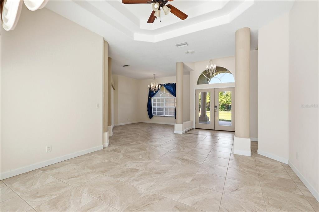 An open foyer and living area feature tile floors, columns, and a tray ceiling — 2635 MANASOTA BEACH ROAD, ENGLEWOOD, FL
