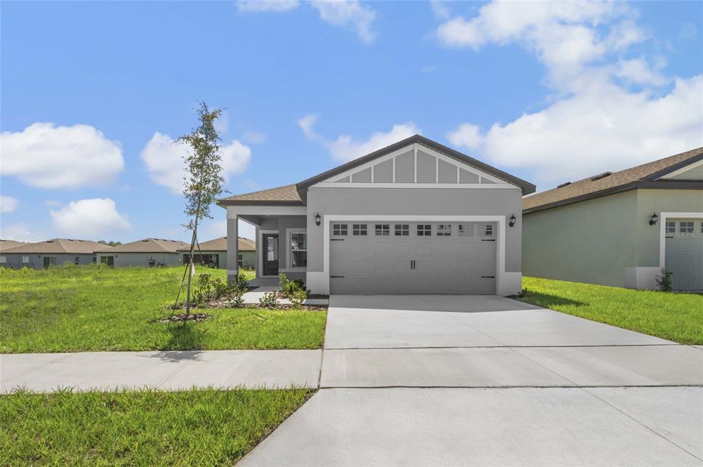 A single-story house with a gray exterior, a two-car garage, and a concrete driveway — 3613 AMANATSU AVENUE, LAKE ALFRED, FL