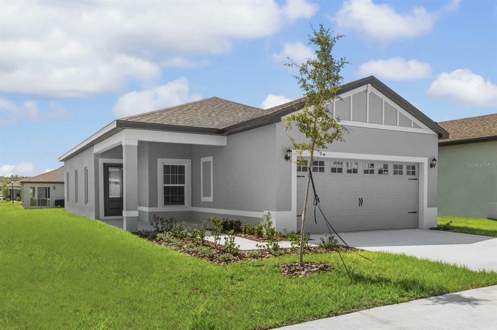 A single-story gray house with a two-car garage and a covered front porch — 3613 AMANATSU AVENUE, LAKE ALFRED, FL