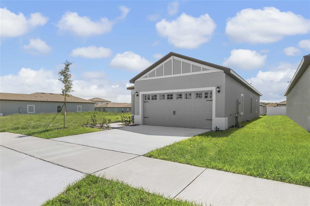 A gray single-story house with a two-car garage and a concrete driveway — 3613 AMANATSU AVENUE, LAKE ALFRED, FL