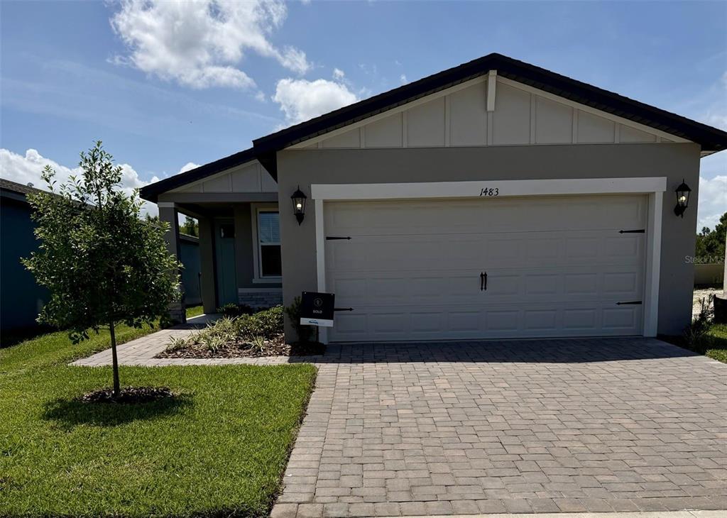 A single-story house with a paved driveway, a two-car garage, and a small front yard — 1483 BREKEY WAY, ZEPHYRHILLS, FL