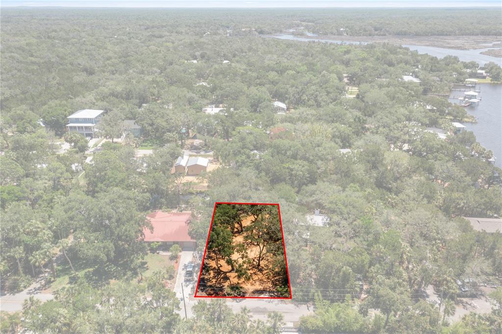 An aerial view shows a vacant, tree-covered lot outlined in red within a residential neighborhood — 6845 S MASON CREEK ROAD, HOMOSASSA, FL