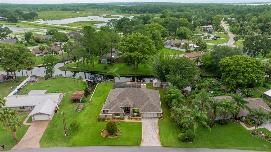 An aerial view shows a single-story house with a pool cage and a large lawn — 36 SE CHINICA DRIVE, SUMMERFIELD, FL
