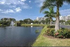 A pond with a fountain sits in front of palm trees and multi-story apartment buildings — 2333 FEATHER SOUND DRIVE UNIT A208, CLEARWATER, FL