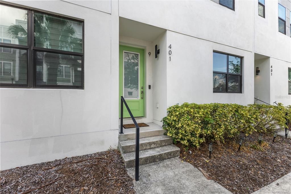 The exterior of a modern townhouse features a lime green front door and concrete steps — 401 N OREGON AVENUE UNIT 9, TAMPA, FL