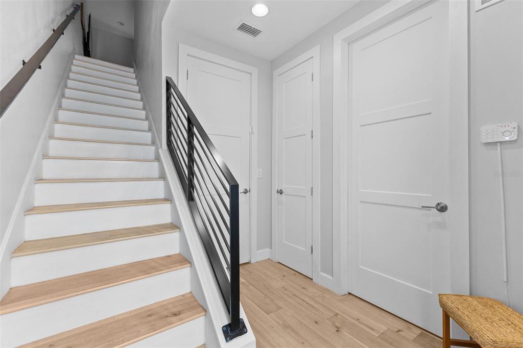 A staircase with light wood treads and a black metal railing leads to an upper floor — 401 N OREGON AVENUE UNIT 9, TAMPA, FL