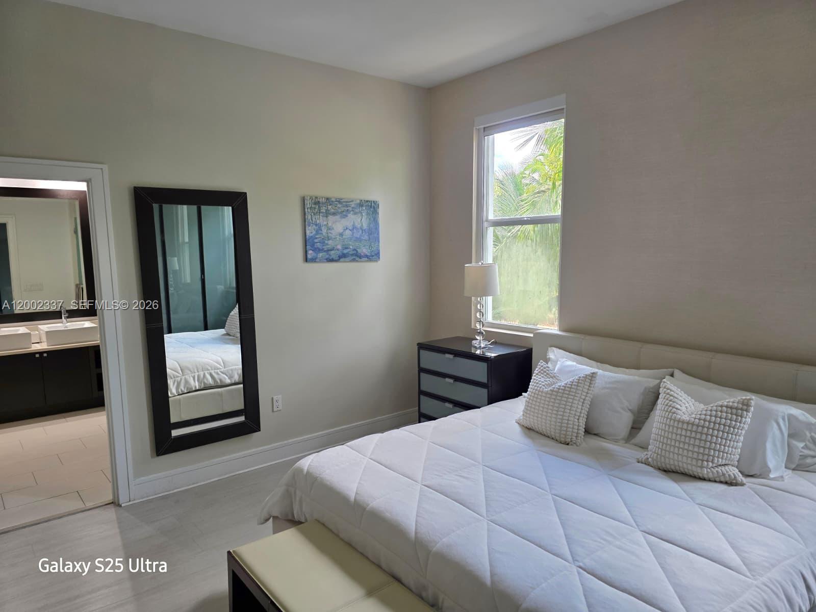 A bedroom features a bed, a dresser with a lamp, a mirror, and an attached bathroom — 5300 NW 87th Ave # 1416, Doral FL 33178, DORAL, FL