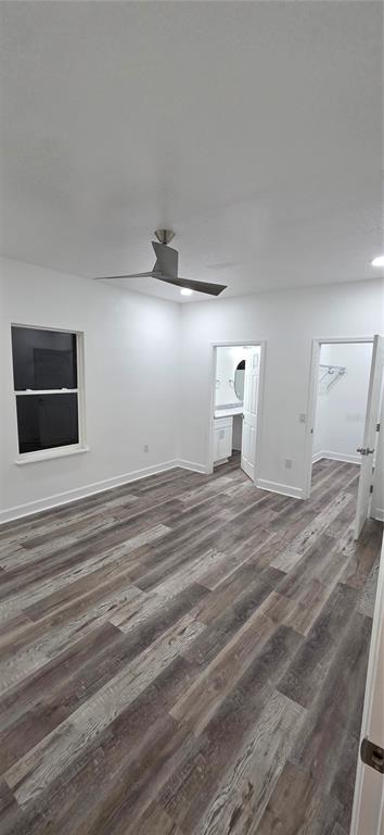 A bedroom with white walls, wood-look flooring, a ceiling fan, and two doorways — 350 NE 20TH TERRACE, GAINESVILLE, FL