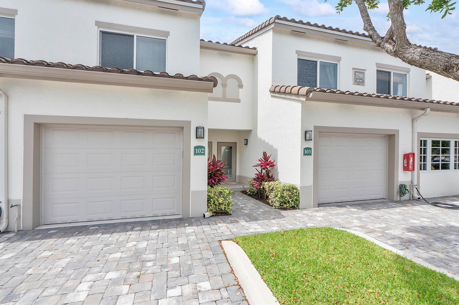 Two attached townhome units feature white stucco exteriors, tile roofs, and individual garages — 3596 S Ocean Boulevard # 102, Highland Beach FL 33487, HIGHLAND BEACH, FL