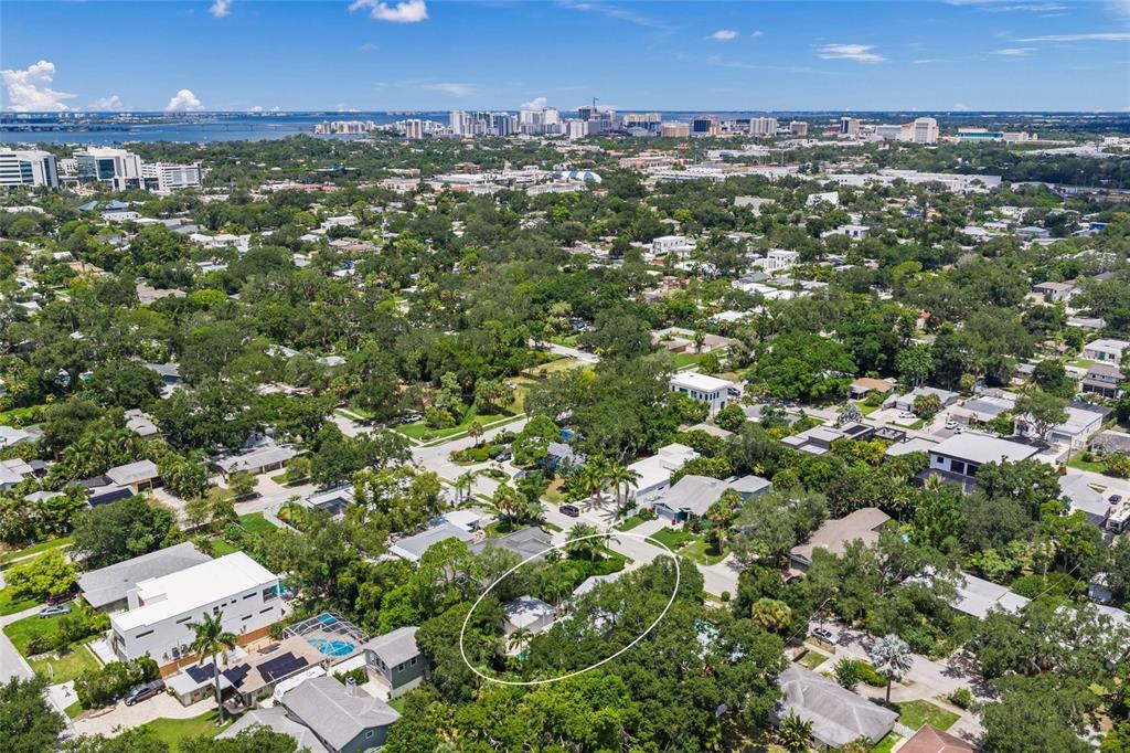 An aerial view shows a residential property circled in a neighborhood with a distant city skyline — 2440 ARLINGTON STREET, SARASOTA, FL