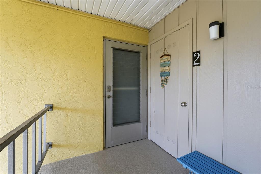 A yellow exterior wall, a screen door, and a closet door marked with a number two — 101 LOUELLA LANE UNIT 2, NOKOMIS, FL