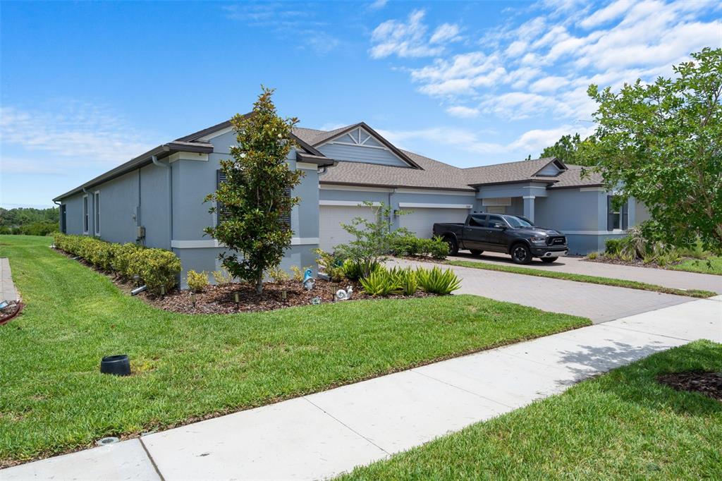 A gray single-story house with a two-car garage and a dark pickup truck parked outside — 10093 CAMPANULA COURT, LAND O LAKES, FL