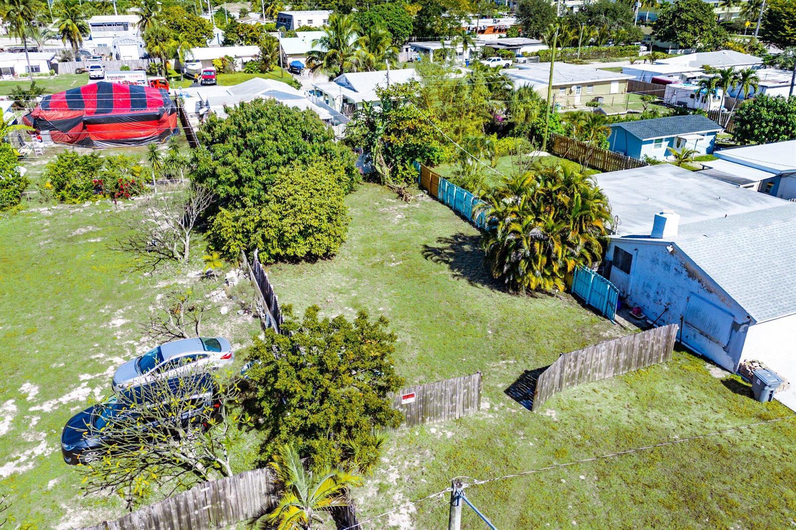 An aerial view shows a vacant grassy lot situated between two residential properties — 1073 Florence Road, Lake Worth FL 33462, LAKE WORTH, FL