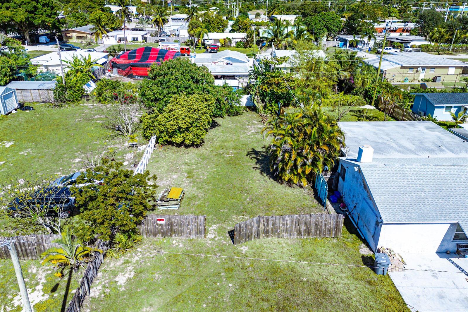 An aerial view shows a grassy residential lot with a fence and a nearby house — 1073 Florence Road, Lake Worth FL 33462, LAKE WORTH, FL