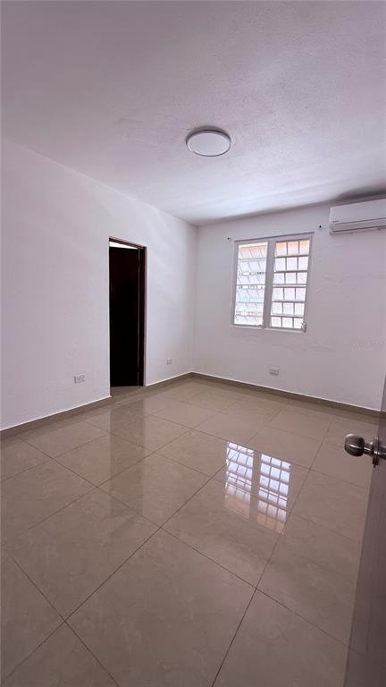 An empty room with light-colored tile floors, white walls, a window, and a ceiling light — 413 EDIFICIO GAITHER PLAZA APT. 3A, SAN JUAN, PR