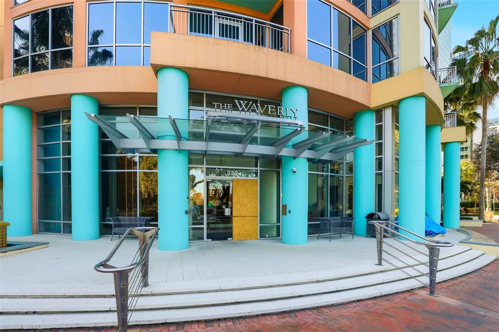 The exterior entrance of a multi-story building features teal columns and a glass canopy — 322 E CENTRAL BOULEVARD UNIT 1109, ORLANDO, FL