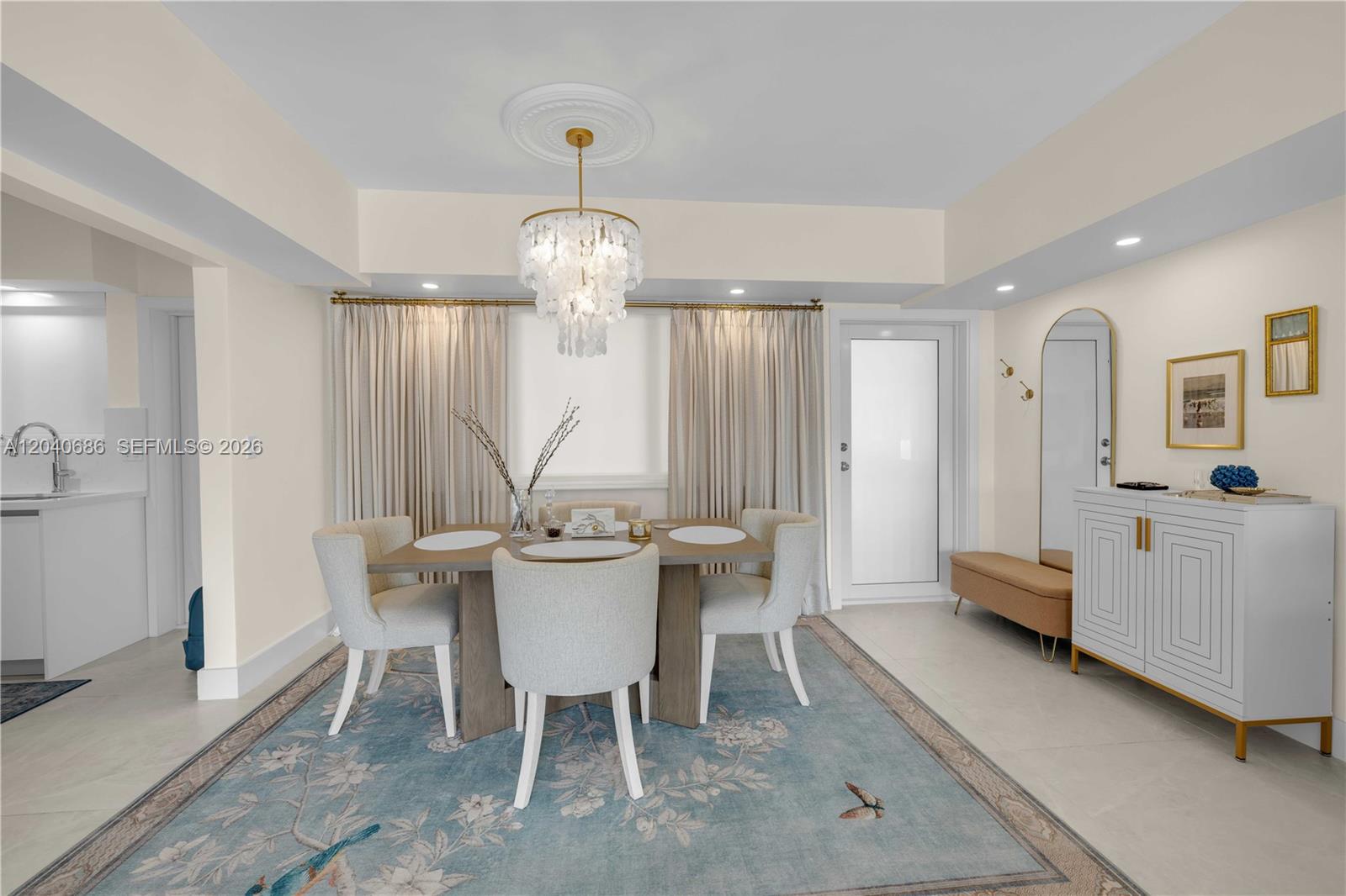 A dining room features a square table, upholstered chairs, a chandelier, and a floral rug — 462 Golden Isles Dr # 211, Hallandale Beach FL 33009, HALLANDALE BEACH, FL