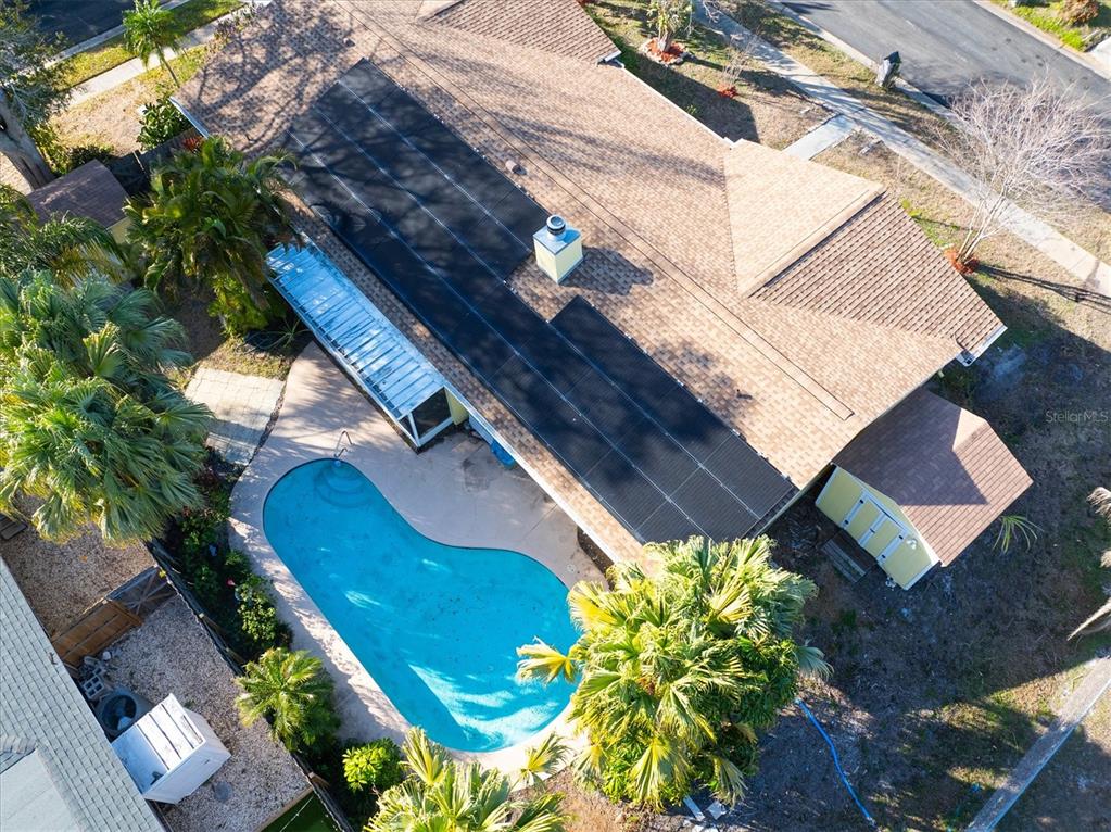 An aerial view shows a house with solar panels on the roof and a swimming pool — 13400 91ST AVENUE, SEMINOLE, FL