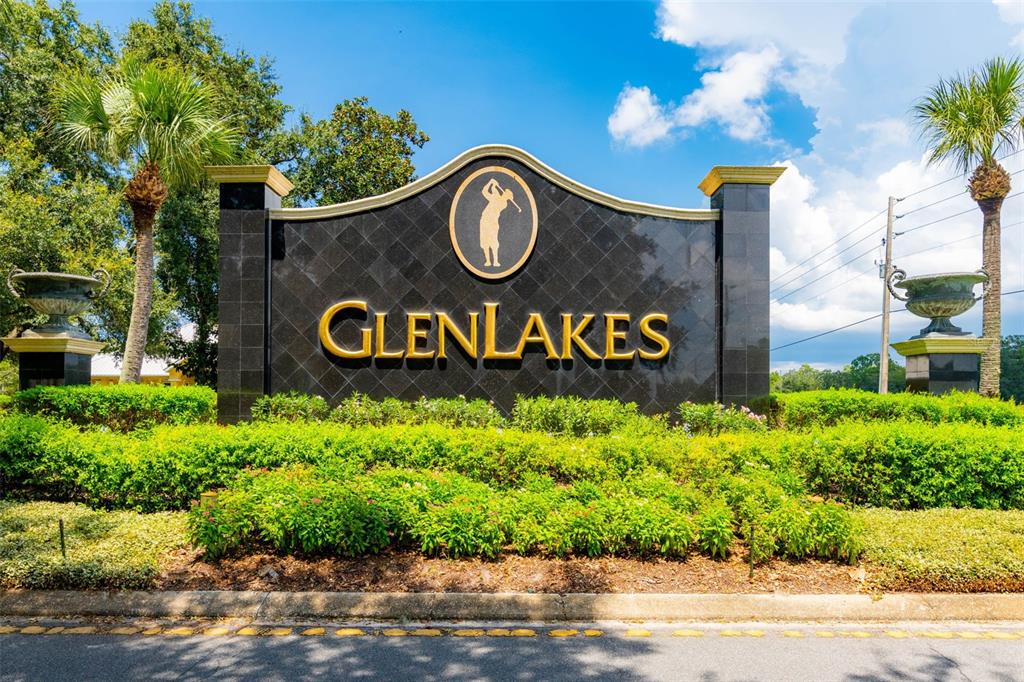 A black stone monument sign with gold lettering and a golfer logo stands outdoors — 9316 GENTLE BEN COURT, WEEKI WACHEE, FL