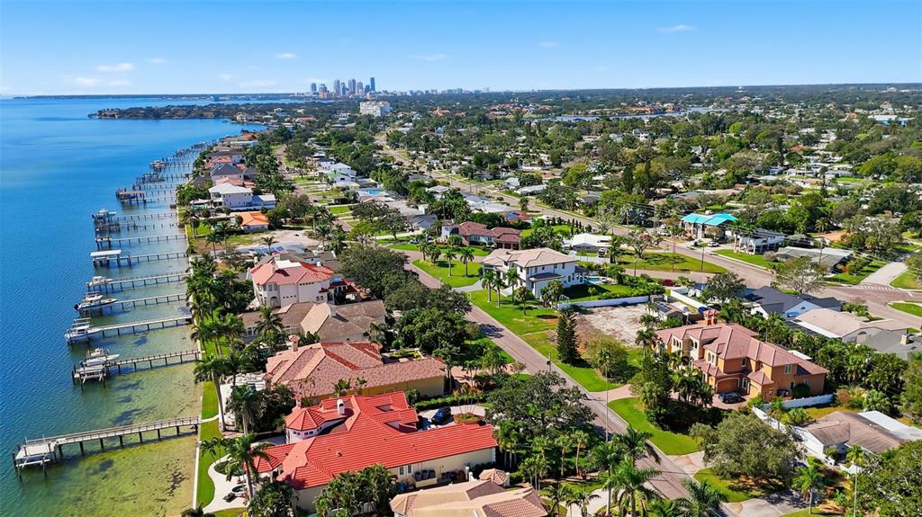 An aerial view shows waterfront homes with private docks along a bay near a city — 4324 BAYSHORE BOULEVARD NE, ST PETERSBURG, FL