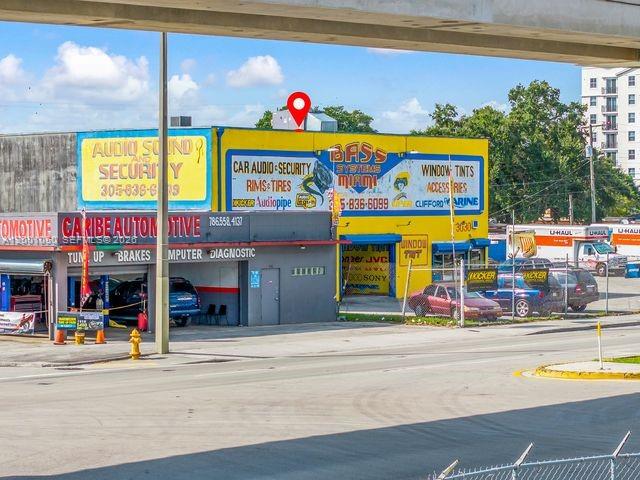 An exterior view of a commercial building with signage for car audio and automotive services — 3030 NW 79th St, Miami FL 33147, MIAMI, FL
