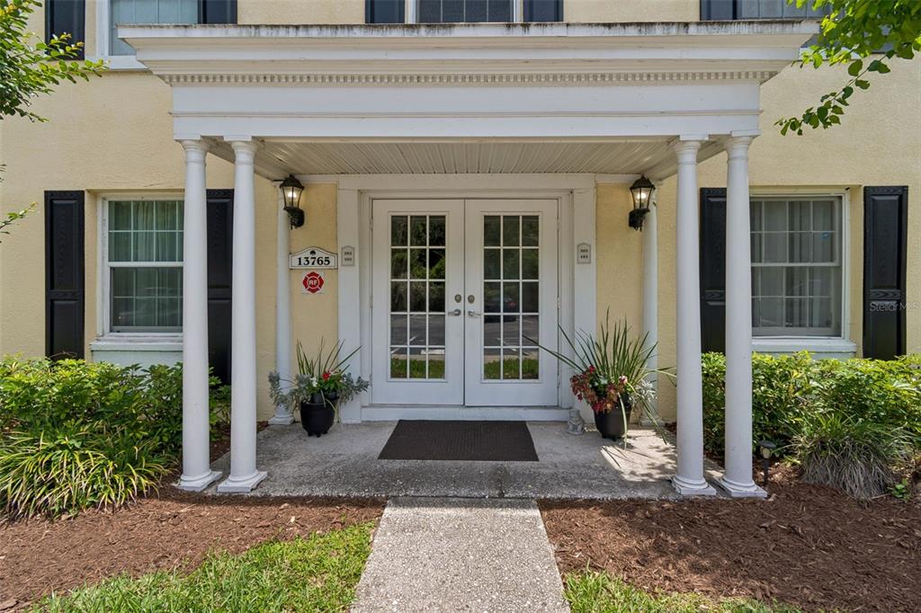 The exterior entrance features a covered porch with white columns and double glass doors — 13765 JUNIPER BLOSSOM DRIVE UNIT 101, TAMPA, FL