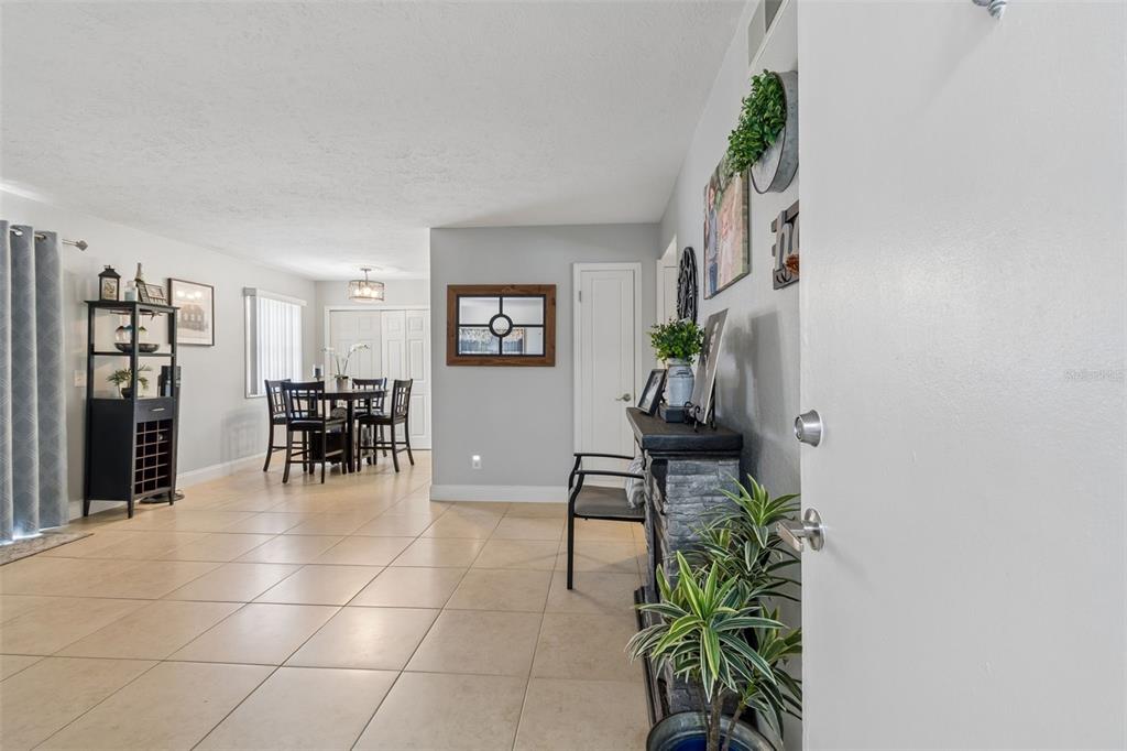A view from an entryway into a dining area with tiled floors and a fireplace — 13765 JUNIPER BLOSSOM DRIVE UNIT 101, TAMPA, FL