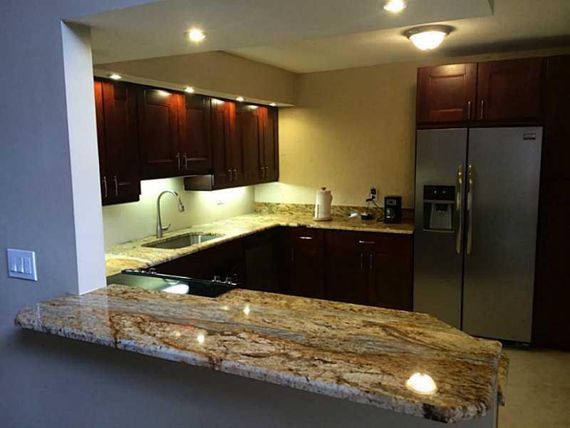 A kitchen features dark wood cabinets, granite countertops, and stainless steel appliances — 363 W Camino Real # 5, Boca Raton FL 33432, BOCA RATON, FL