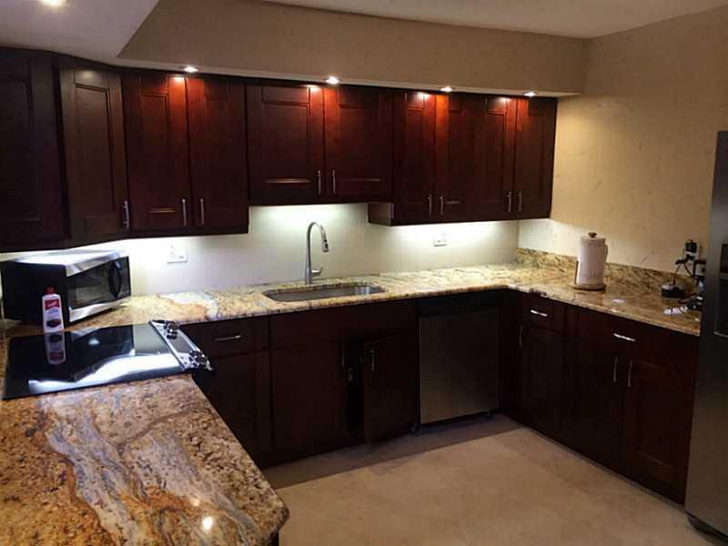 A kitchen features dark wood cabinets, granite countertops, stainless steel appliances, and under-cabinet lighting — 363 W Camino Real # 5, Boca Raton FL 33432, BOCA RATON, FL