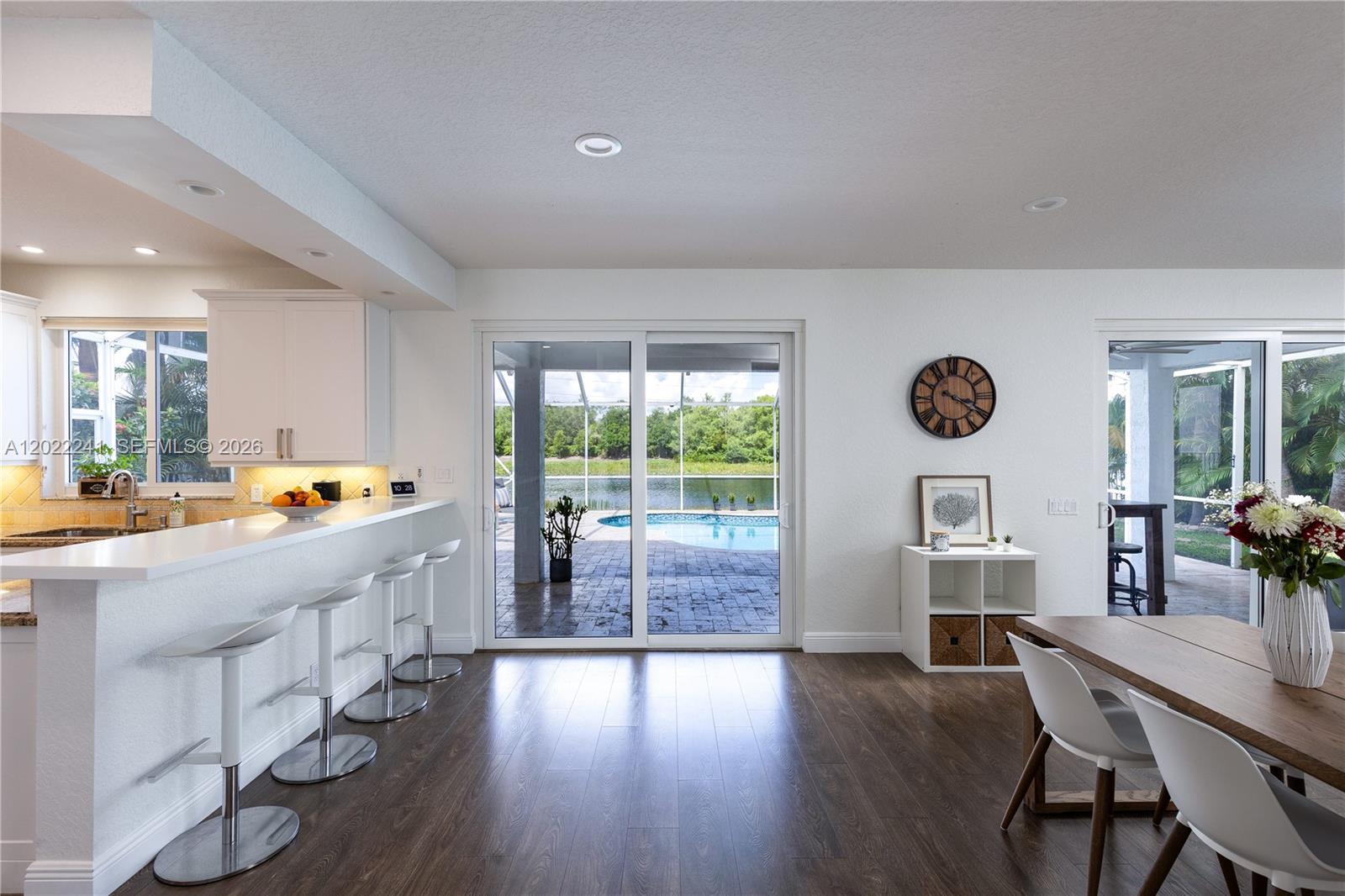 A spacious entryway features dark wood flooring, a glass-railed staircase, and a large wave painting — 2517 Hunters Run Way, Weston FL 33327, WESTON, FL