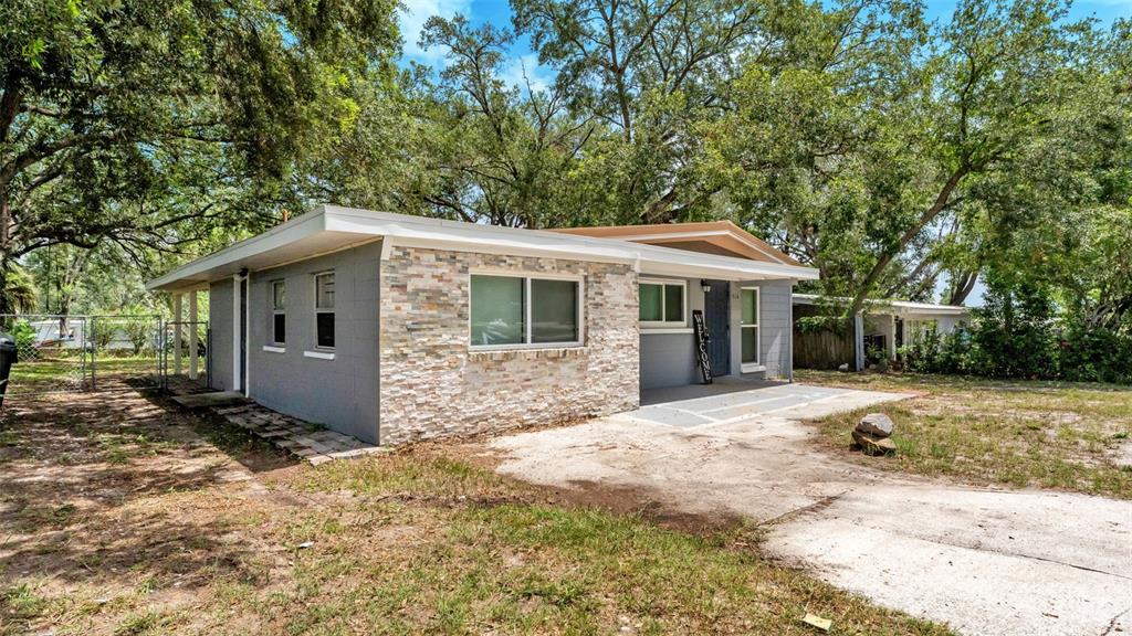 A single-story house with gray walls, stone veneer accents, and a concrete driveway — 516 WESTOVER STREET, LAKELAND, FL