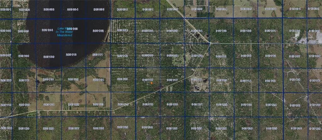 This is a satellite map showing a grid of land parcels with an orange marker — BELMONTE DRIVE, INDIAN LAKE ESTATES, FL