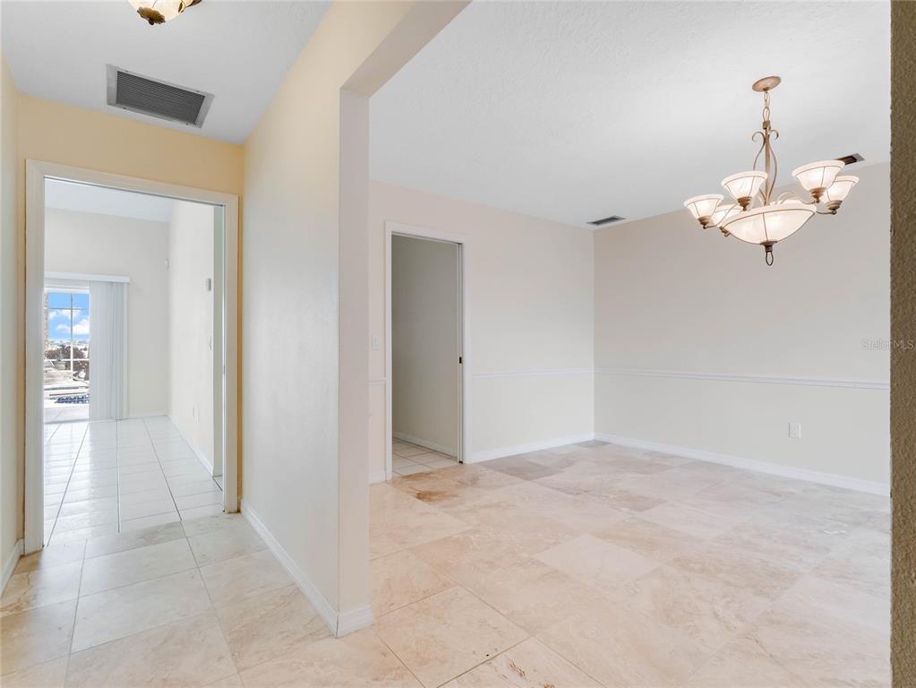 A dining room with tile flooring, a chandelier, and a doorway leading to a sunroom — 9531 BAY VISTA ESTATES BOULEVARD, ORLANDO, FL