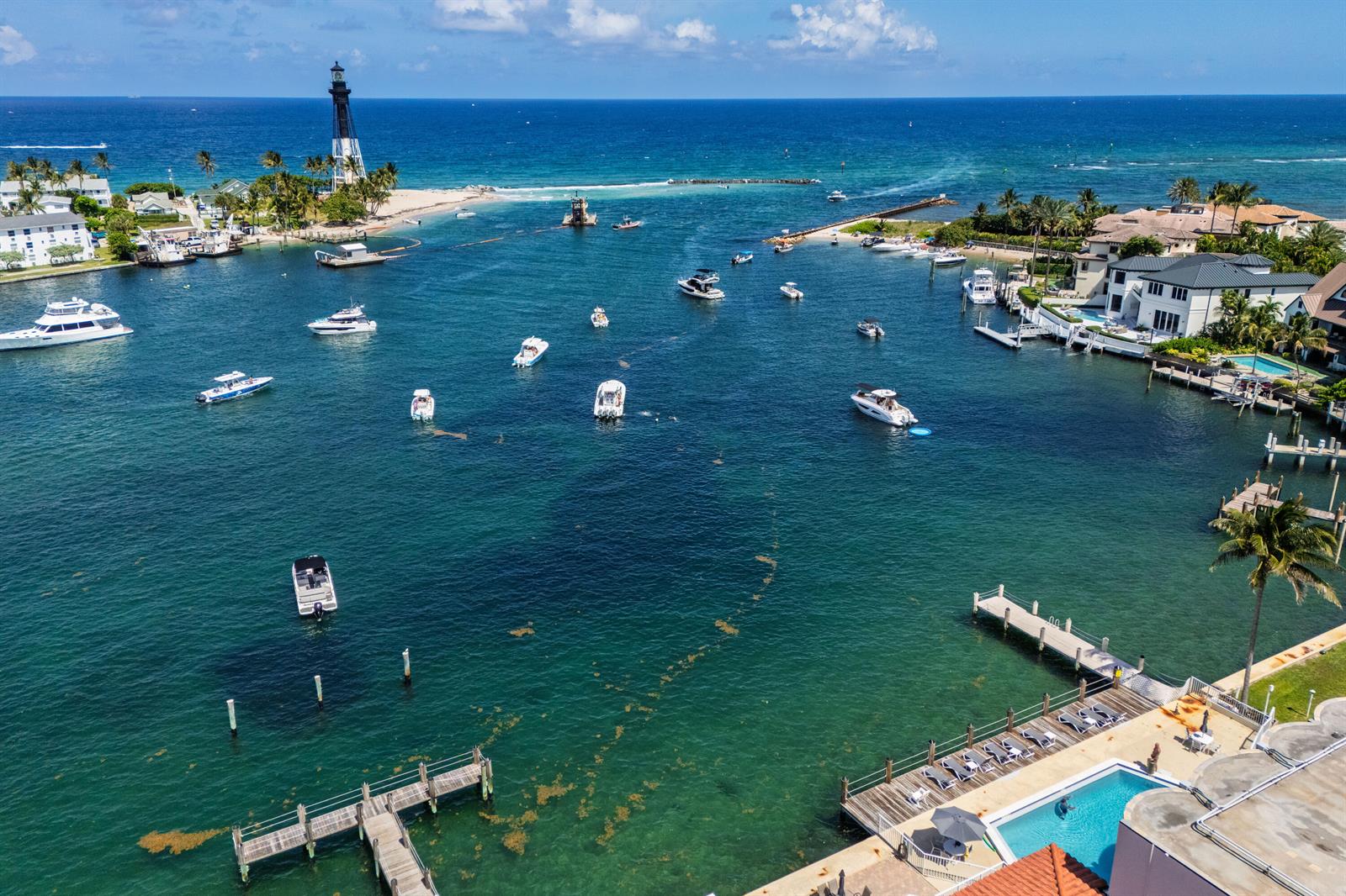 An aerial view shows a coastal waterway with a lighthouse, numerous boats, and residential docks — 2508 Bay Drive Unit 105, Pompano Beach FL 33062, POMPANO BEACH, FL