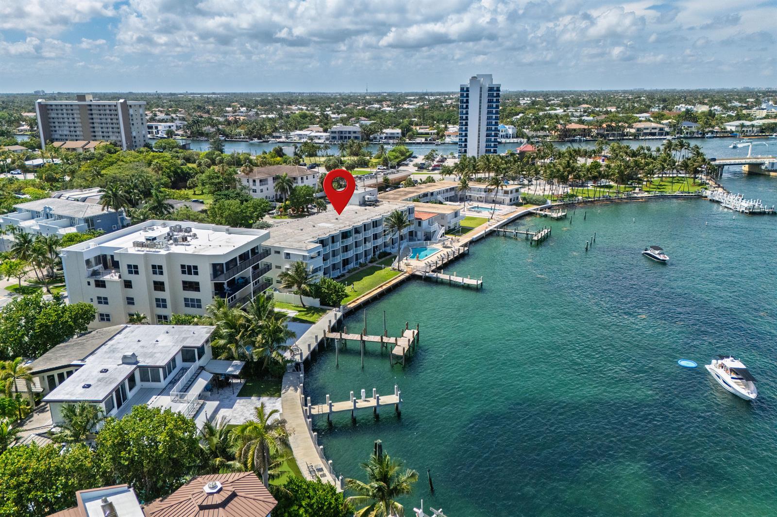 An aerial view shows a waterfront apartment complex with a pool and private boat docks — 2508 Bay Drive Unit 105, Pompano Beach FL 33062, POMPANO BEACH, FL
