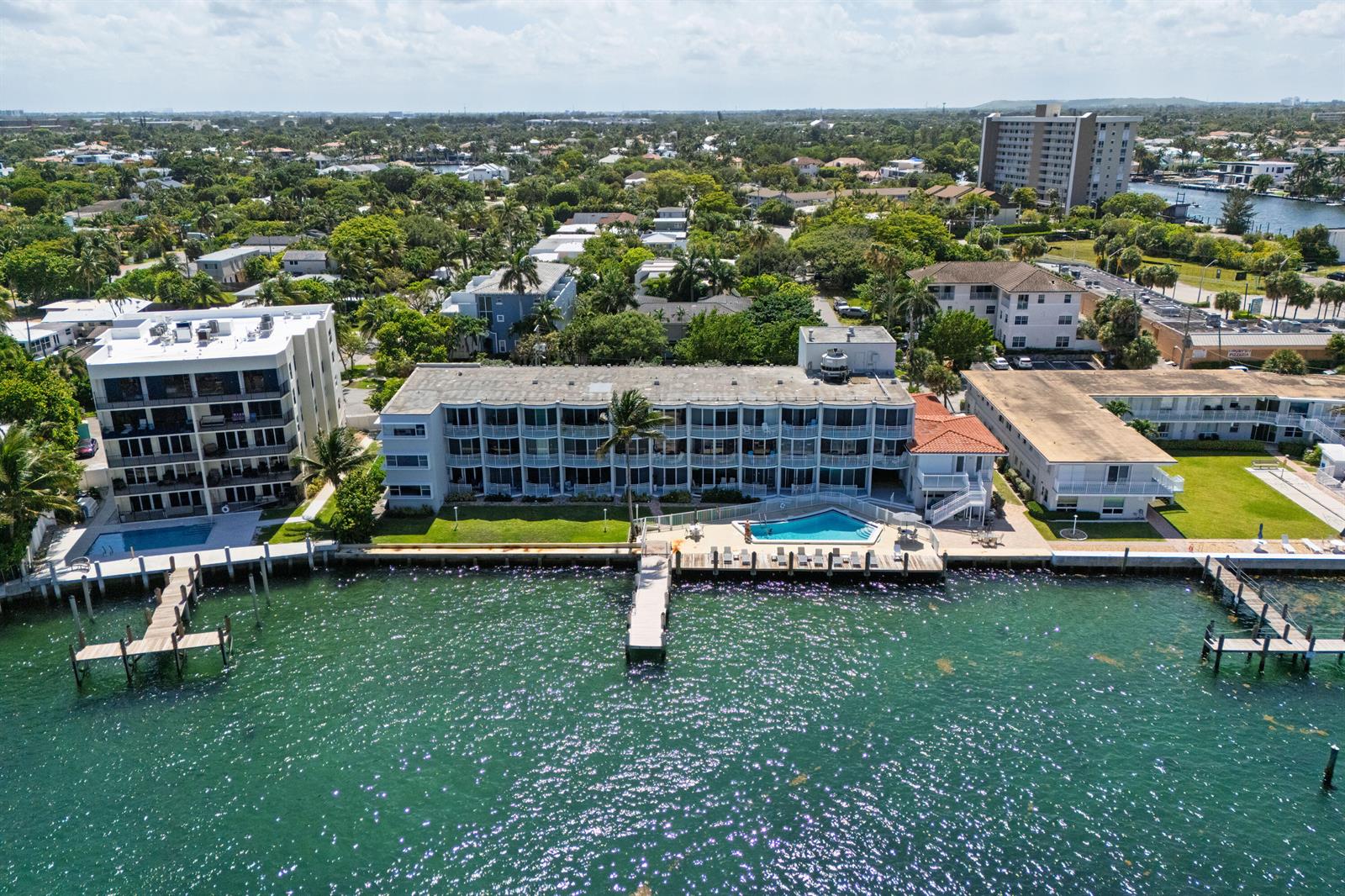 An aerial view shows waterfront apartment buildings with swimming pools and private docks — 2508 Bay Drive Unit 105, Pompano Beach FL 33062, POMPANO BEACH, FL