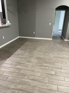 An interior view of a room with gray walls and light-colored wood-look tile flooring — 5148 MAGNOLIA PRESERVE BOULEVARD, WINTER HAVEN, FL