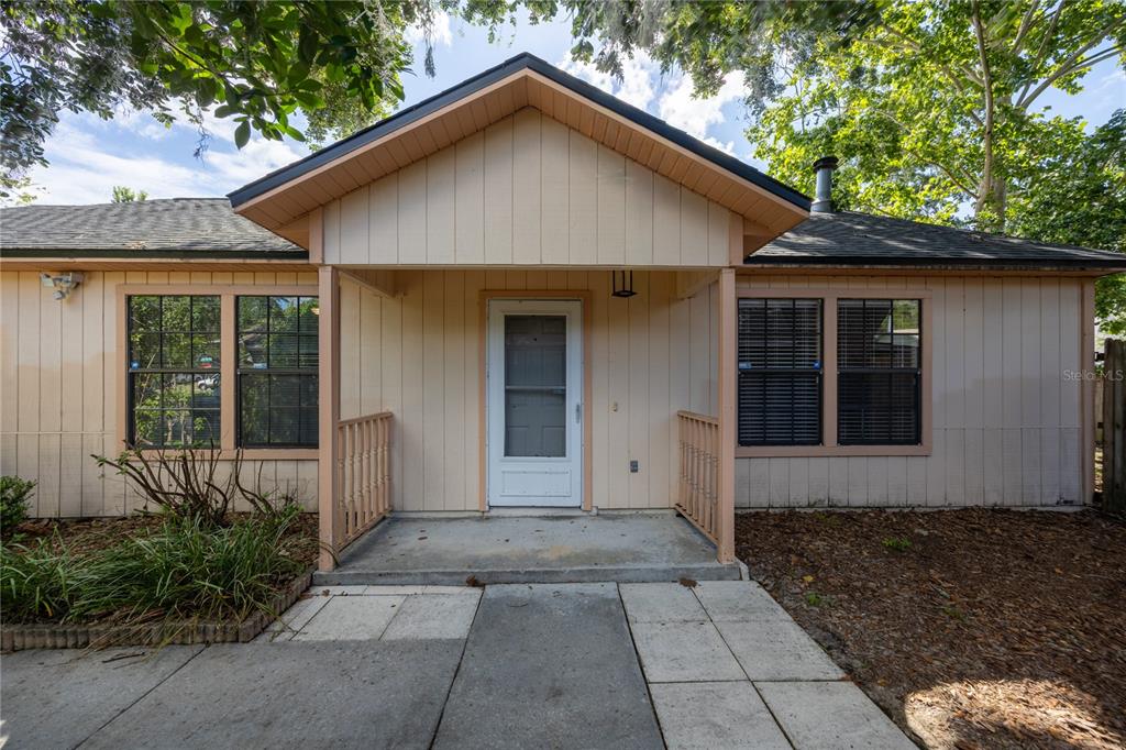 A single-story house with light-colored vertical siding, a covered front porch, and a concrete walkway — 2951 SW 40TH AVENUE, GAINESVILLE, FL